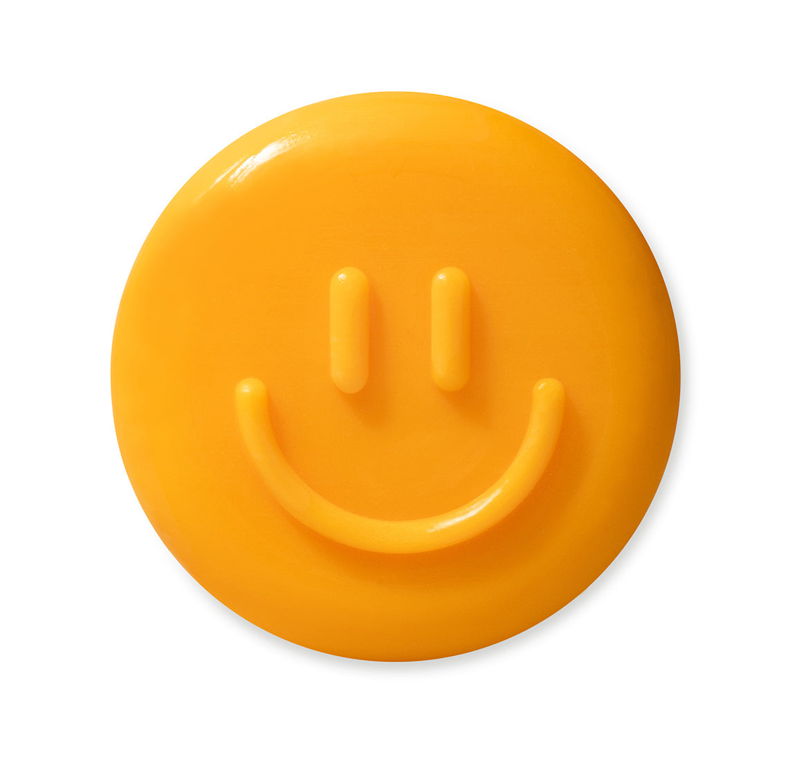 eine runde, orangefarbene Seife in Form eines lächelnden Smileys