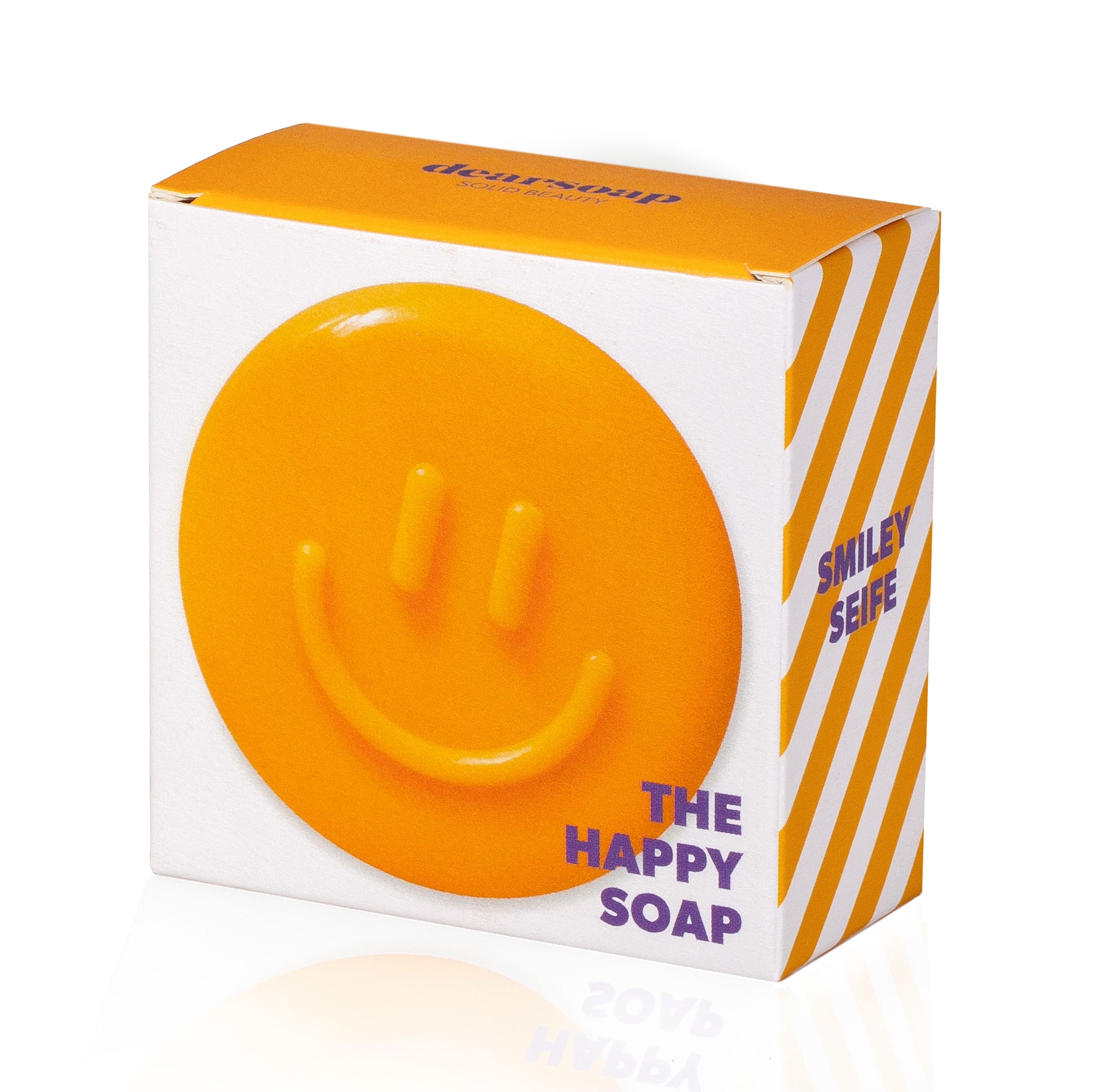 die Vorderseite der Verpackung der orangefarbenen Smileyseife zeigt das Produkt selbst und den Titel "The happy soap"